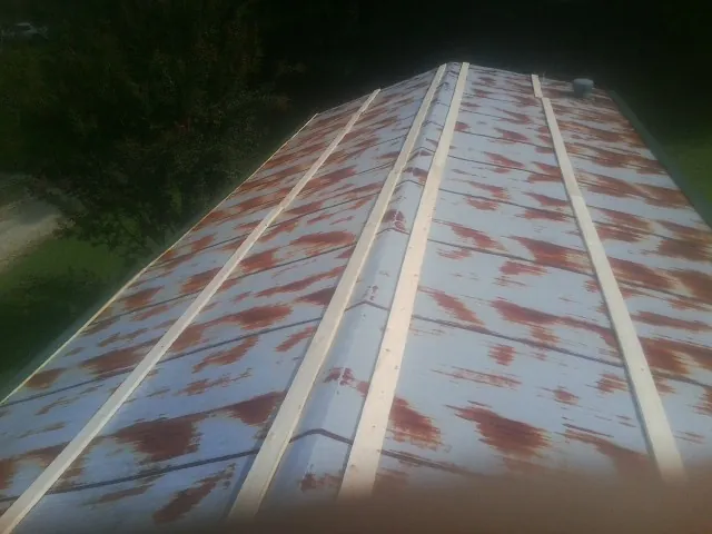 Rusted metal roof panels with new wood purlins before replacement — Storm Damage Roof Repair in Scituate by Roofing Brothers