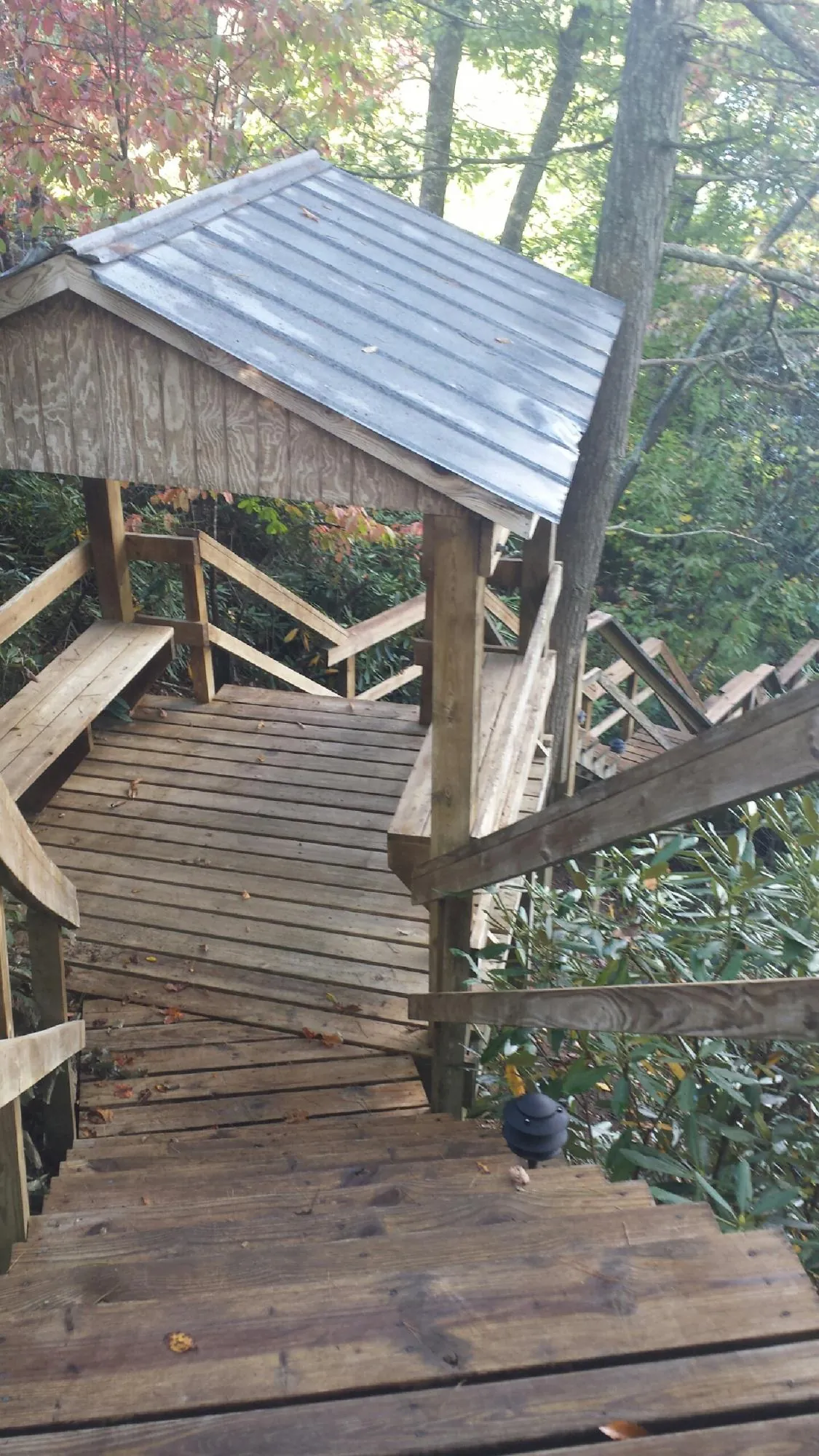 Metal roofed shelter over wooden steps on a wooded walkway — Skylight Repair & Installation work by our crew in Scituate
